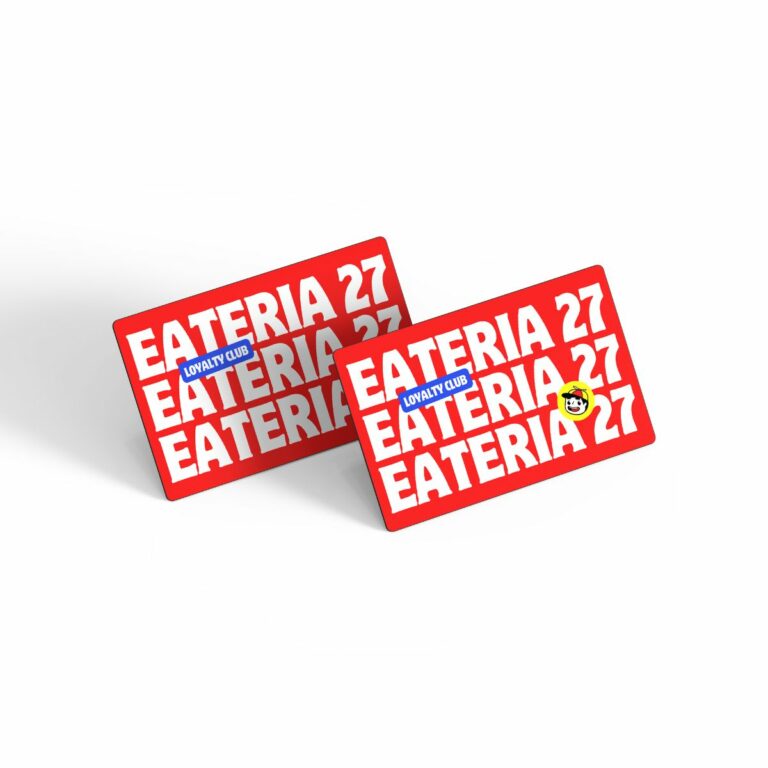 Two red loyalty cards with the text EATERIA 27 in bold white letters, stacked diagonally. One card has a small blue LOYALTY CLUB label and a smiling yellow emoji. The design is clean and modern on a white background, perfect for exclusive members clubs seeking sleek EPOS systems integration.